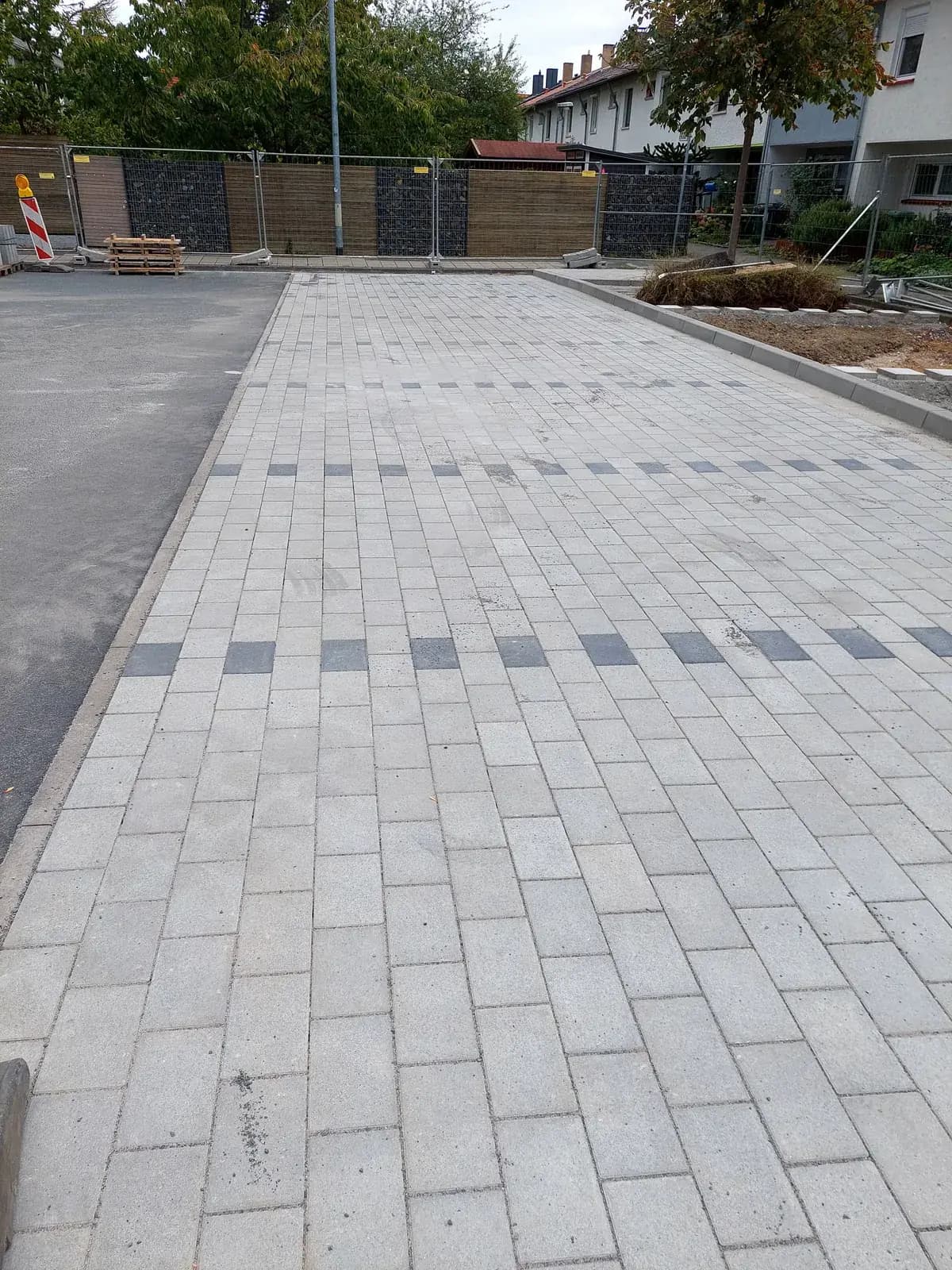 Frisch verlegtes Betonsteinpflaster mit dunklen Akzentsteinen auf einem Stellplatz – Pflasterarbeiten von SHG Galabau in Bad Kreuznach